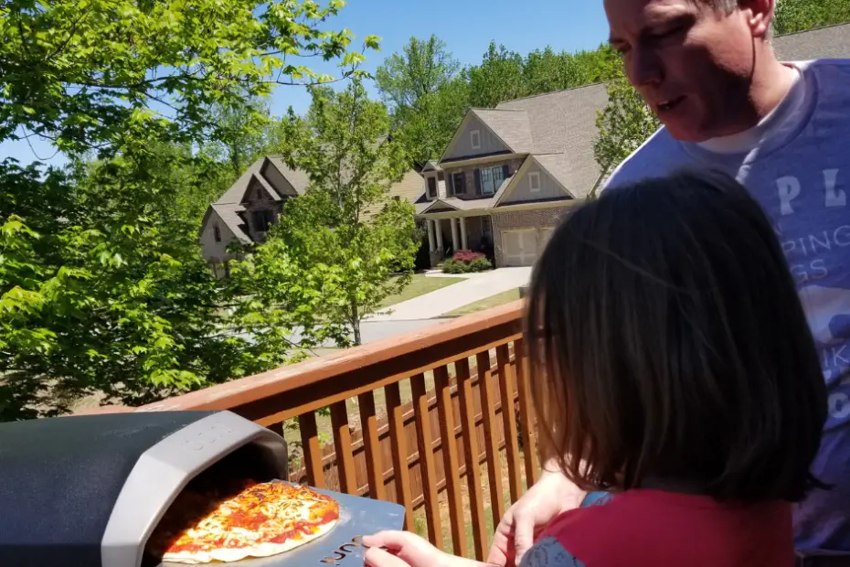 Father teaches daughter how to cook pizza on ooni koda pizza oven