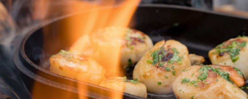 scallops and shrimp cooking on ooni cast iron oval skillet
